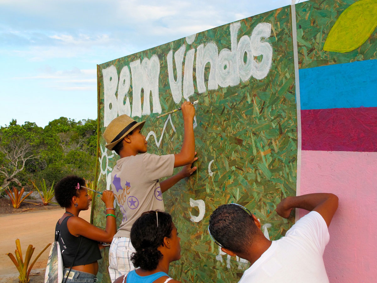 Kids of CCCultura Santo André painting the wall around Campo Bahia, the base camp of the German national football team during the 2014 FIFA World Cup. (© Theresa Ernst)